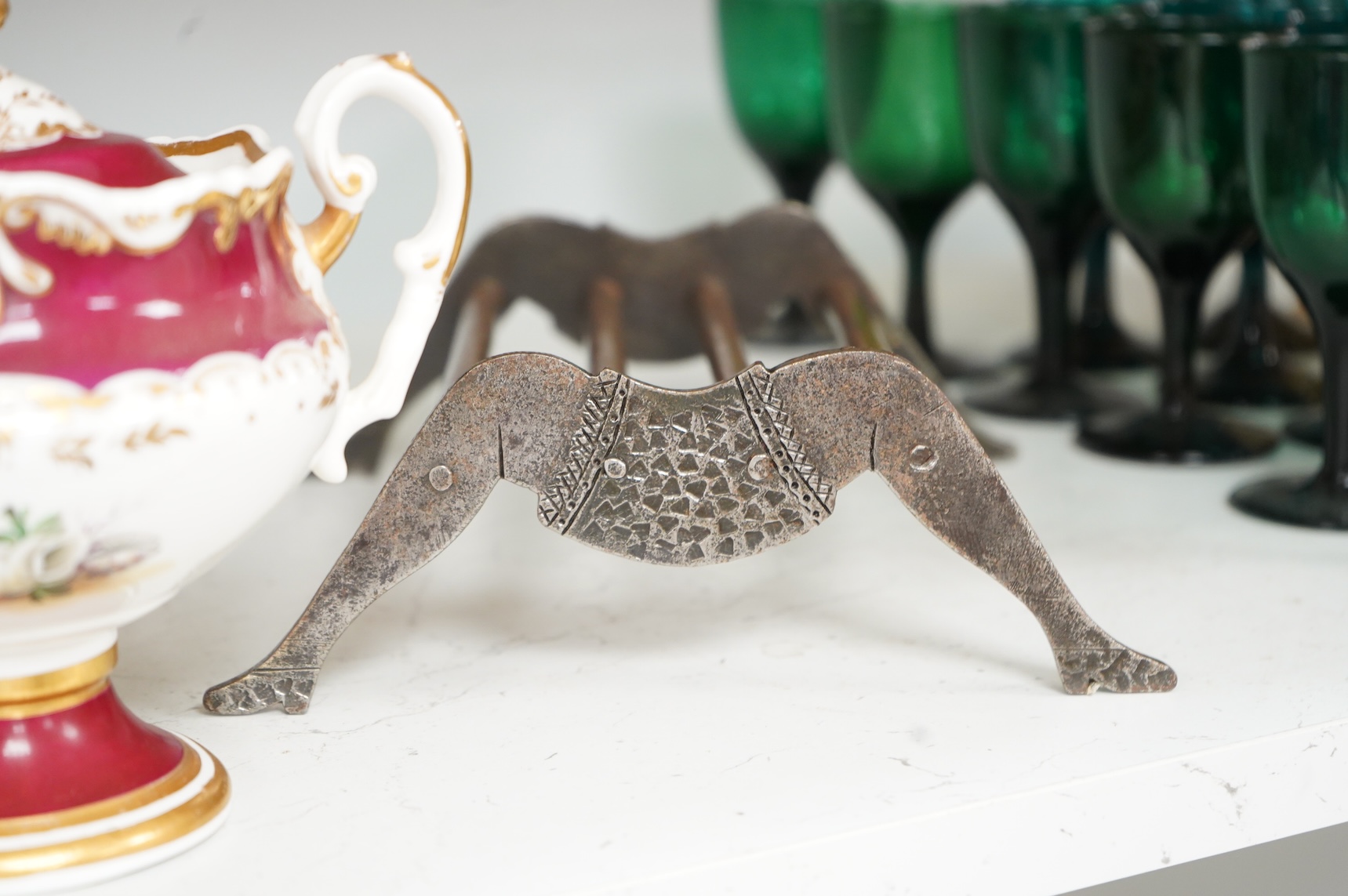 An engraved iron and copper novelty lady's legs stand, 21cm wide